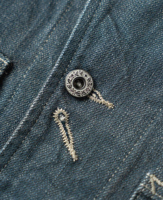 Sage blue denim jacket button detail with metal snap and stitched placket