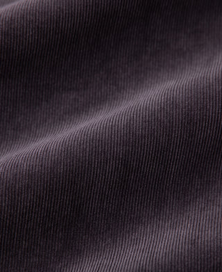 Purple corduroy fabric close-up showing fine vertical ribbed texture