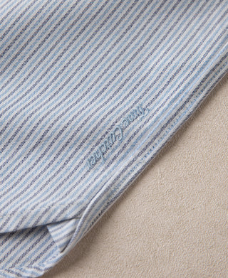 Light blue striped shirt side seam with embroidered brand label