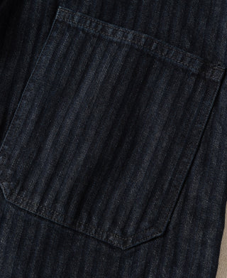 Indigo denim work pants close-up of front patch pocket and herringbone texture