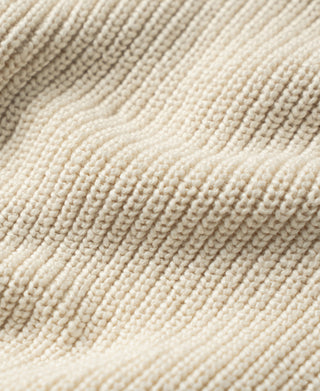 Cotton sweater close-up showing raised seed-stitch knit and ribbed trim