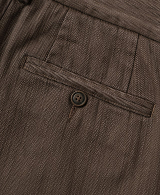 Brown back pocket patch with button closure on herringbone trousers