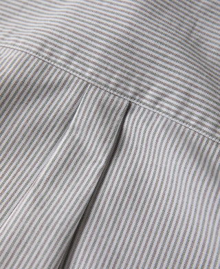 Oxford shirt sleeve seam close-up, blue-and-white stripe pattern.