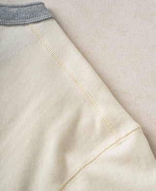 Cream cotton henley sleeve hem with ribbed edge and stitched seam detail