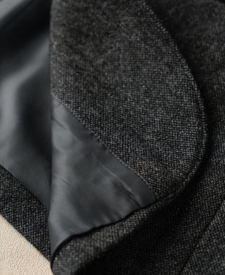 Gray wool suit jacket pocket with curved flap and dark satin lining