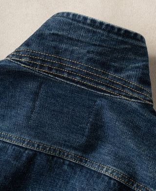 Indigo denim jacket shoulder and upper back close-up with double-row yellow topstitching