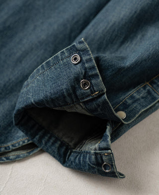 Washed denim sleeve cuff with snap hardware and vent opening detail