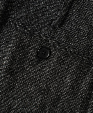 High-waisted wool trousers, close-up of dark button on gray front placket
