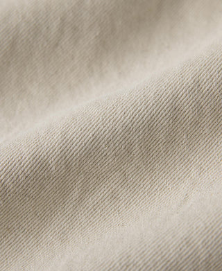 Natural twill fabric weave close-up with subtle surface marks