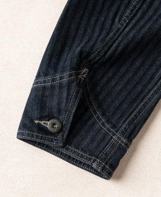 Indigo denim jacket cuff with round snap button and stitched hem