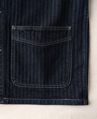 Indigo denim jacket sleeve hem with rectangular patch pocket and bar tacks