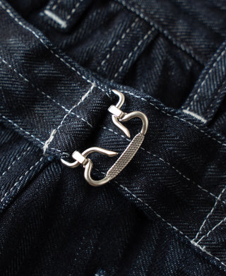 Indigo denim buckle-back hardware detail with metal rings and straps