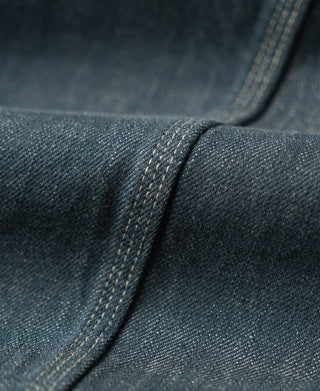 Sage blue denim jacket shoulder seam with topstitching and fabric texture detail