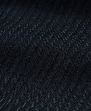 Indigo herringbone denim fabric close-up showing fine diagonal ribs