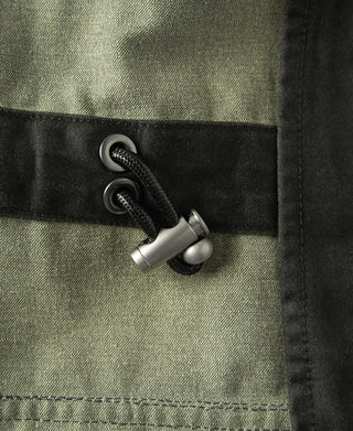 Field jacket cuff detail with adjustable snap and black cord tie closure