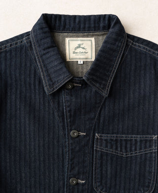 Indigo herringbone denim jacket with pointed collar and buttoned chest pocket
