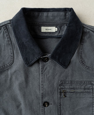 Gray-blue canvas jacket with ribbed collar, button placket, and chest pocket