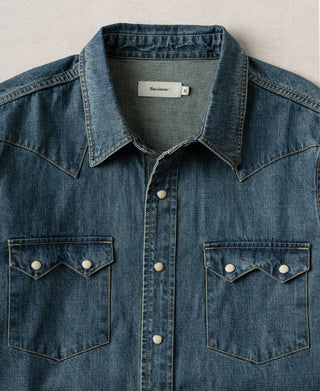 Washed denim western shirt with collared neckline, button placket, and flap chest pockets