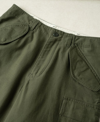 Olive cargo pants waistband close-up with button fly and side cargo pocket