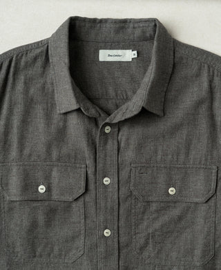 Dark gray work shirt with spread collar, button placket, and two chest pockets