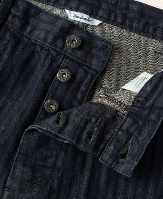 Indigo herringbone denim work pants with buttoned flap pockets and interior print