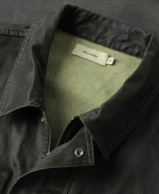 Field jacket front corner detail with zipper opening and snap button