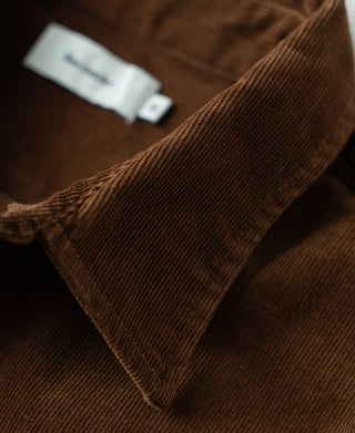 Brown corduroy fabric close-up at collar seam and textured ridges