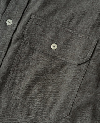 Dark gray work shirt chest pocket with white buttons and stitched detailing