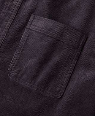 Purple corduroy chest pocket close-up with stitched edges and button-up placket