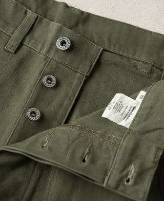Olive deck pants interior waistband with three metal button fasteners and size tag.