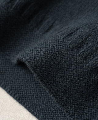Close-up of textured wool knit and raised ribbing on the dark blue sweater
