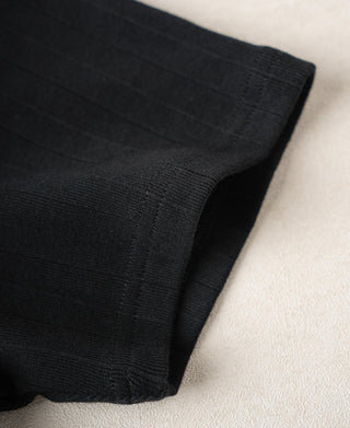 Close-up of vintage black ribbed T-shirt sleeve cuff and side seam.
