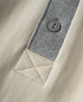 Close-up of henley placket with gray contrast tape and a small round button