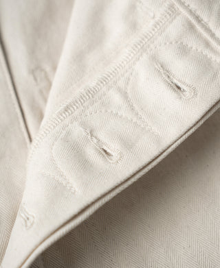 White pants seam and stitched detailing near pocket and side opening