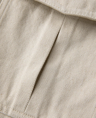 Natural twill jacket panel seam and stitched edge near pocket opening