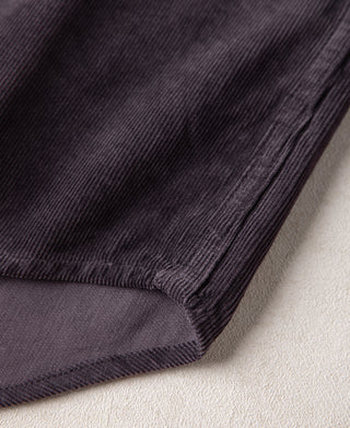Purple corduroy shirt hem corner with cuff stitching and dark button placket edge