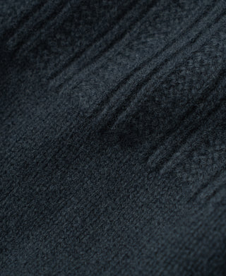 Close-up of the dark blue sweater's soft wool fibers and vertical ribbed knit