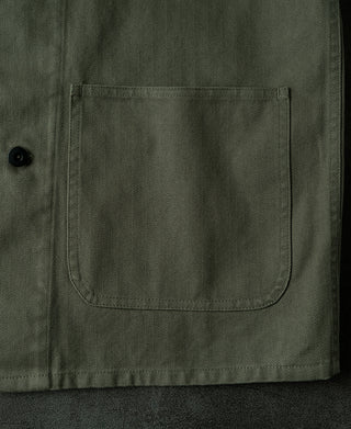 Olive field jacket flap pocket with button closure at the lower front.
