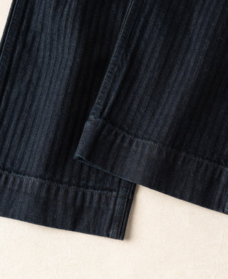 Indigo herringbone denim work pants with gathered hem and stitched cuffs