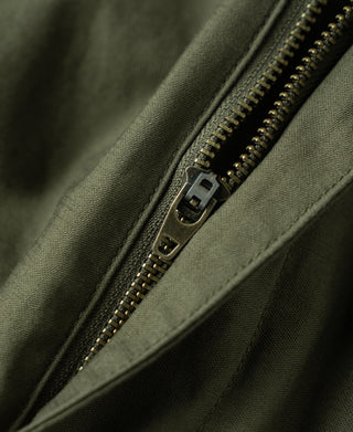 Olive cargo pants zipper detail with metal pull and reinforced seam tape