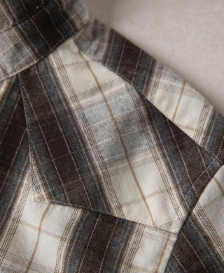 Plaid yoke seam and curved chest pocket area on western shirt