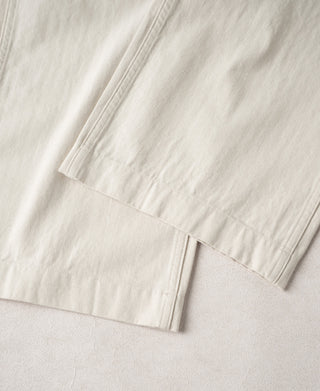 White pants hem with side vent detail and pressed fold at cuff