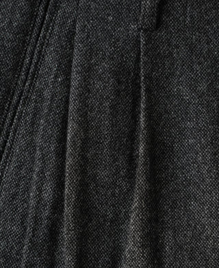 Vertical pleats across gray wool trouser front
