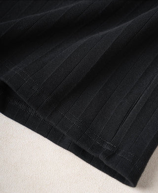 Vintage black ribbed cotton T-shirt sleeve hem close-up with textured knit pattern.