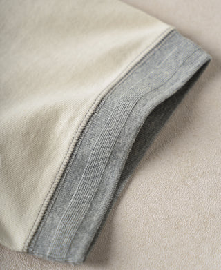 Cream henley shirt sleeve cuff with gray contrast ribbing and stitched edge