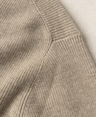 Ecru knit cardigan side with ribbed panel and stitched seam detail.