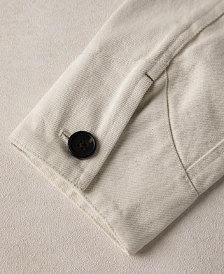 Natural twill Eisenhower jacket sleeve with buttoned cuff and welt seam detail.