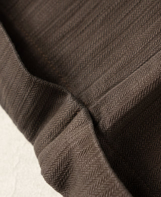 Brown herringbone fabric close-up with stitched fold and lining