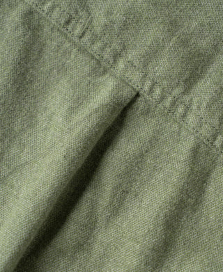 Sage green brushed flannel fabric close-up with textured weave.
