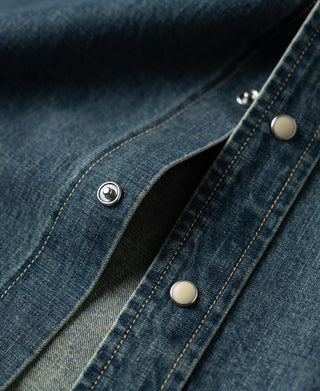 Washed denim western shirt sleeve cuff with metal snap buttons and topstitched placket